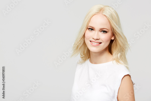 Happy, smile and portrait of woman in studio with a positive, confident and happiness mindset. Beauty, face and young female model from Australia with blonde hair by gray background with mockup space