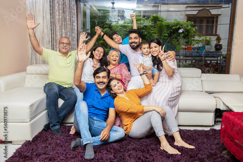 Portrait of Happy cheerful indian joint family sitting together at home. Asian senior and young couple with their kids having and laughing. photo