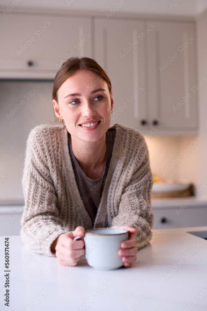 Young Woman Relaxing At Home In Kitchen Holding Hot Drink Young Woman Relaxing At Home In Kitchen Holding Hot Drink