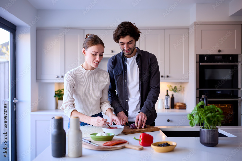 Couple In Kitchen At Home Making Homemade Pizza Together Couple In Kitchen At Home Making Homemade Pizza Together
