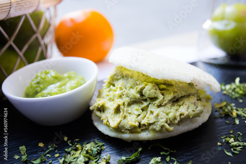 Pulled chicken avocado arepa. The arepa is a food of pre-Columbian origin, made from ground dry corn dough or precooked cornmeal, circular and flattened.
