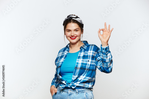Smiling Woman Ok Gesture Isolated. Portrait of Satisfied Plus Size Girl Standing, Looking at Camera and Showing Ok Sign Gesture. Indoor Studio Shot Isolated on White Background 