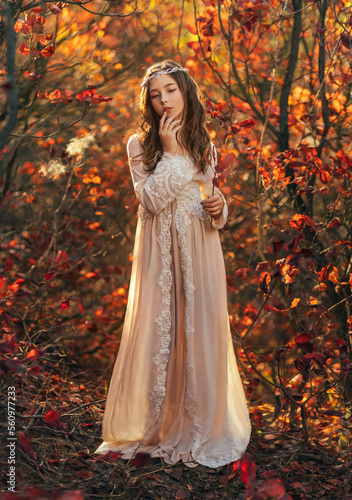 Fantasy portrait teenage princess girl walking in forest, blond flowing hair cute face. White vintage dress, silver crown diadem on head. Autumn nature red orange leaves trees. Elf nymph young woman