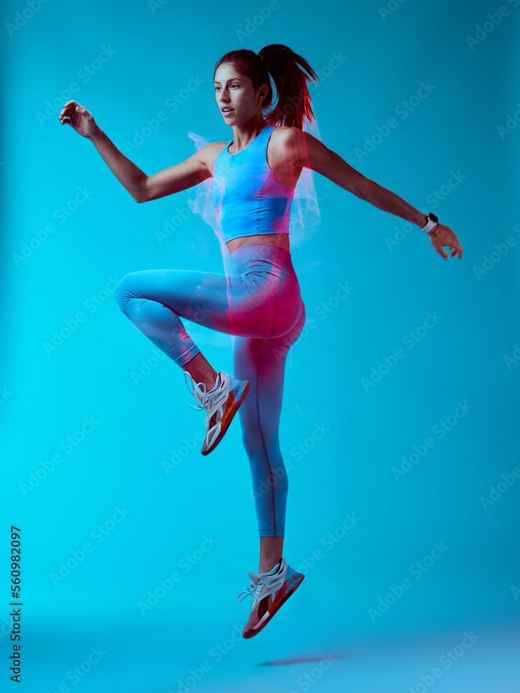 A fit sportswoman jumping and doing exercises. Long exposure capture movement.