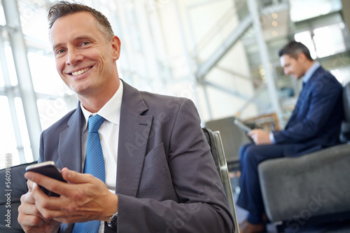 Smile, corporate or businessman with phone for invest strategy, finance growth or financial blog news. Travel, happy or CEO in airport lobby for social media, networking or internet website review