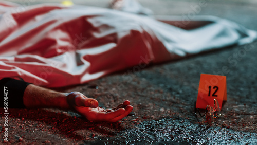 фотографія Close Up Low Angle: A Corpse with a Bloody Hand Lying on the Floor and Covered