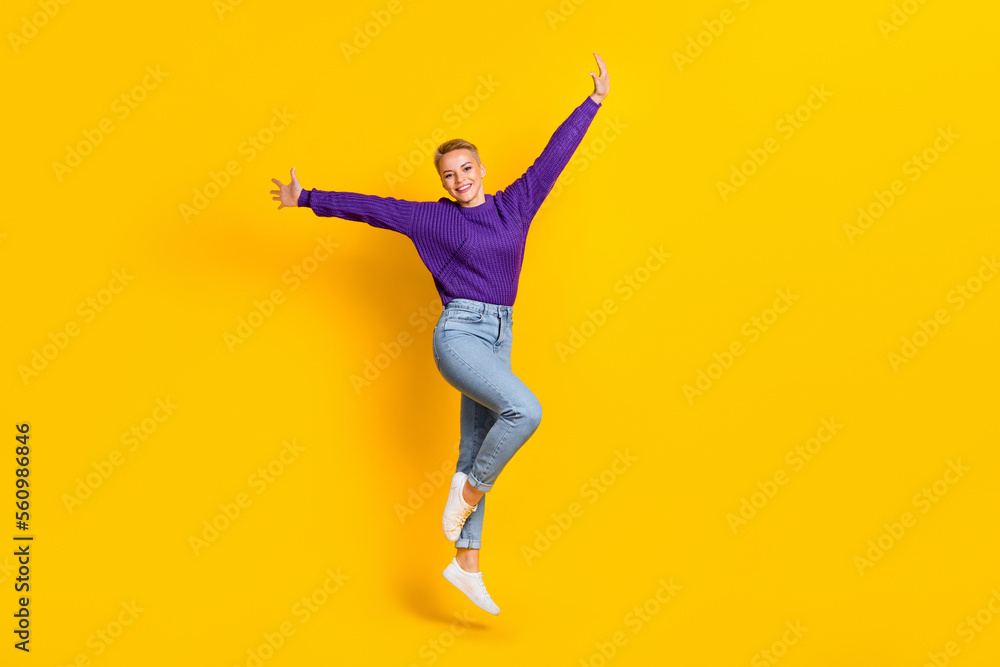 Full body photo of satisfied glad lady jumping good mood raise arms isolated on yellow color background