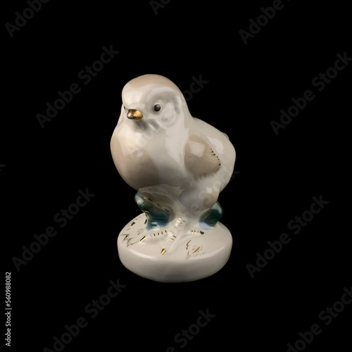 antique figurine of a chicken on a black isolated background. chicken toy. vintage porcelain bird figurine