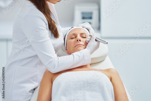 Woman having permanent eyebrows cosmetology treatment in salon
