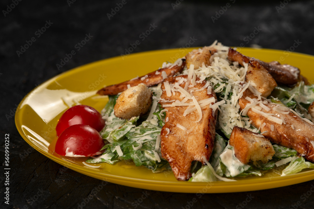 Grilled chicken breast with vegetables and herbs . Caesar salad