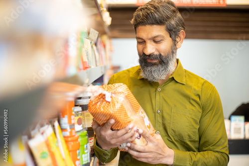 Bild auf Leinwand Mature Indian man buying at grocery shop