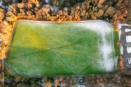 Field with tall goal post for Irish national sport rugby, hurling, camogie and Gaelic football covered with snow. Cold winter season. Training ground area. photo