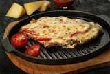 Grilled meat baked with cheese and tomatoes
