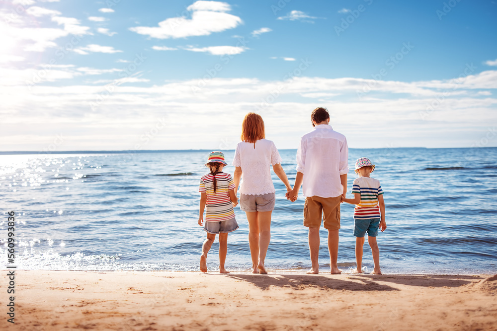 Mother and father with their children standing on the beach on the resort. Mother and father with their children standing on the beach on the resort.