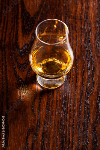 glass of whisky spirit brandy on dark brown background © Olga Miltsova