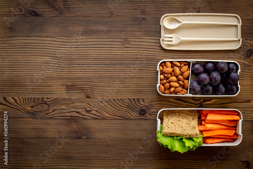Food in lunch boxes with bamboo cutlery, top view