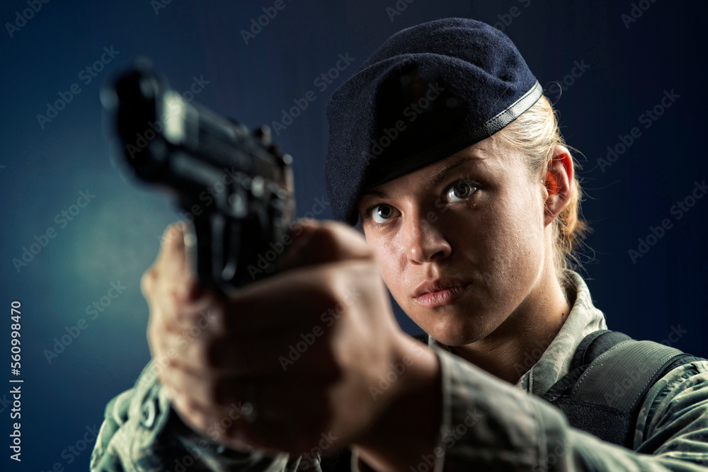 A Caucasian, female, Air Force Security Forces Airman in uniform poses with her M-9 pistol. A Caucasian, female, Air Force Security Forces Airman in uniform poses with her M-9 pistol.