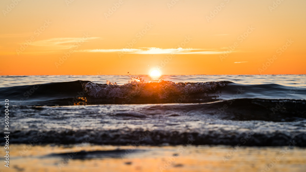 Low angle shot of waves in orange sunset conditions at the baltic sea