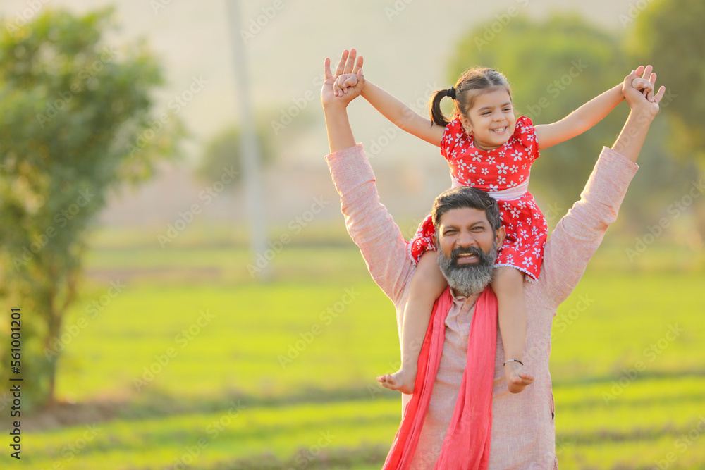 Happy indian farmer with daughter at agriculture field.