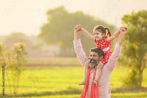 Happy indian farmer with daughter at agriculture field.