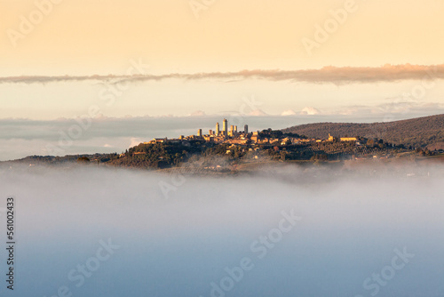 Fototapeta Naklejka Na Ścianę i Meble -  San Gimignano, Siena. Veduta della cittadina al tramonto tra cielo e nebbia