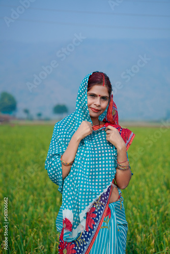 Indian rural woman standing at agriculture field. photo