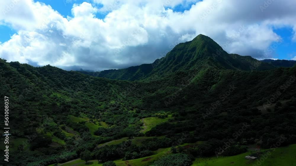 Aerial Forward Shot Of Green Landscape Vehicles Moving On Road Against Cloudy Sky - Kaneohe, Hawaii