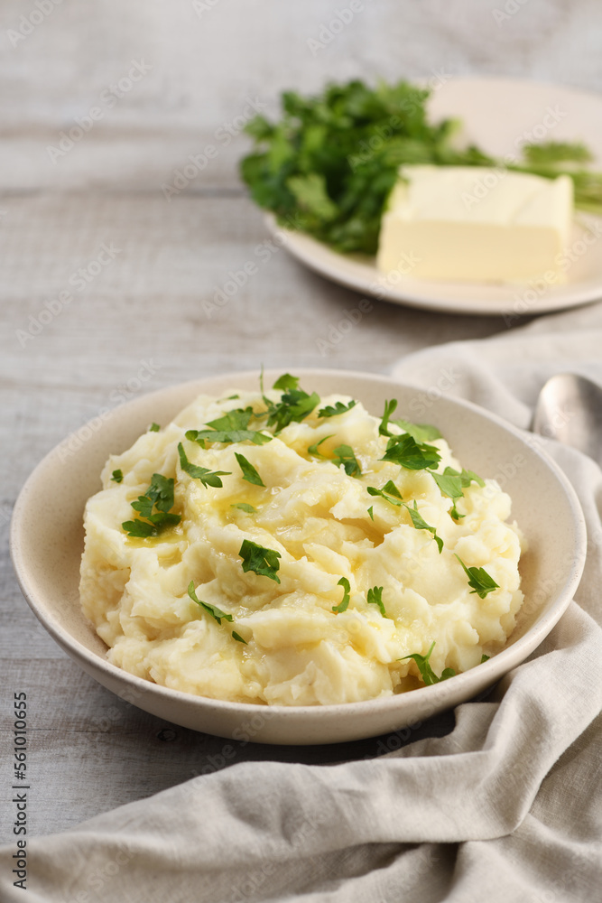 A plate of mashed potatoes poured with melted butter and seasoned with greens A plate of mashed potatoes poured with melted butter and seasoned with greens