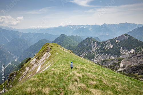 Young child boy hiker conquer the peaks of amazing mountain trail Monte Montusel in Friuli-Venezia Giulia, Italy photo