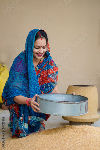 Indian rural woman cleaning wheat at home photo