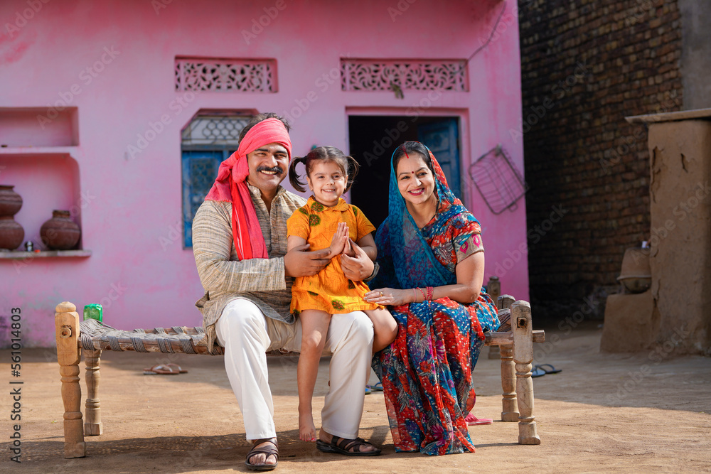 Happy indian farmer with wife and daughter at home.