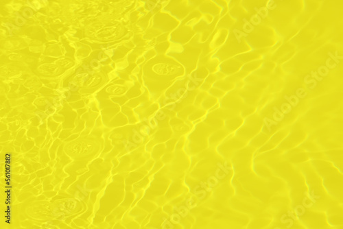 Defocus blurred transparent yellow colored clear calm water surface texture with splashes and bubbles. Trendy abstract nature background. Water waves in sunlight with caustics. Gold watercolor shine