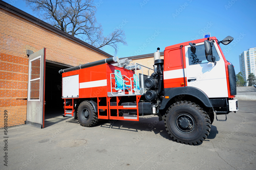Fototapeta premium Fire truck driving out of the garage for firefighting, firehouse