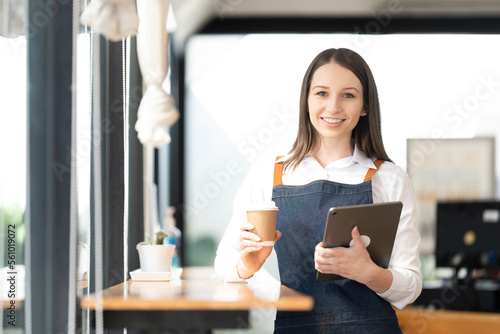 Opening a small business, AHappy Asian woman in an apron standing near a bar counter coffee shop, Small business owner, restaurant, barista, cafe, Online, SME, entrepreneur, and seller concept photo