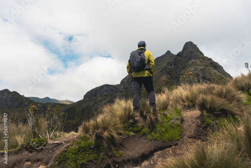 man hiker with backpack in front of a mountain photo