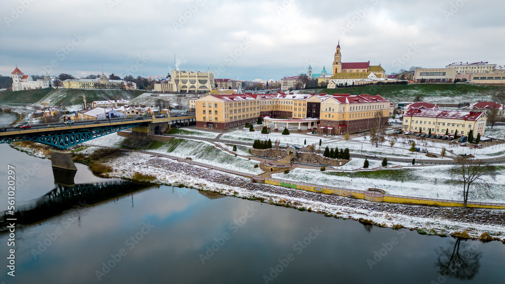 A modern new building of a fashionable university in winter on the lake shore. The historical center of the city is covered with snow, the bridge over the river is covered with ice. snowstorm in city