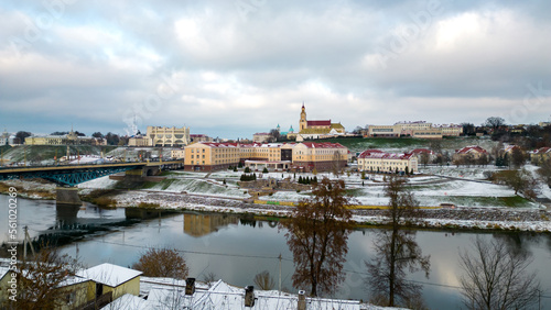 A modern new building of a fashionable university in winter on the lake shore. The historical center of the city is covered with snow, the bridge over the river is covered with ice. snowstorm in city