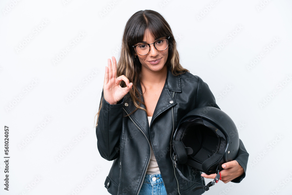 Young caucasian woman with a motorcycle helmet isolated on white background showing ok sign with fingers Young caucasian woman with a motorcycle helmet isolated on white background showing ok sign with fingers