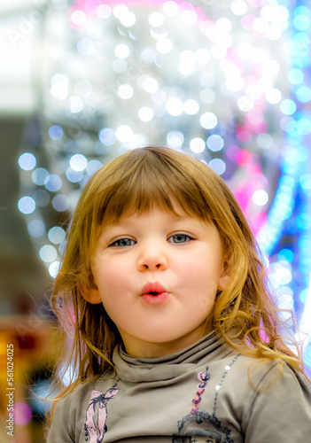 Amazed portrait of a little girl in the middle of Christmas lights