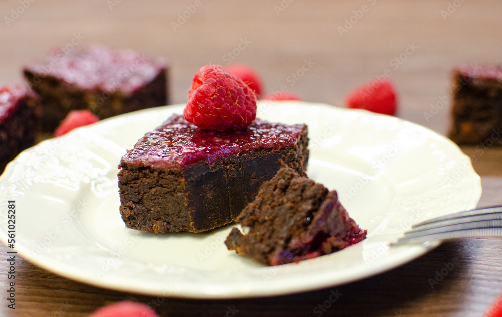 Chocolate brownies with raspberries on white plate Chocolate brownies with raspberries on white plate