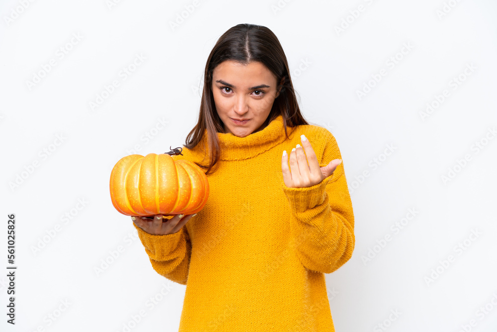 Young caucasian woman holding a pumpkin isolated on white background inviting to come with hand. Happy that you came Young caucasian woman holding a pumpkin isolated on white background inviting to come with hand. Happy that you came