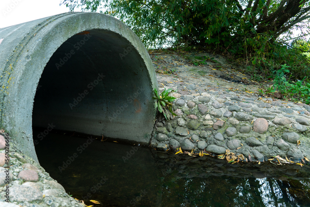 A large concrete pipe for diverting the river under the highway. Leaky dirty water from large concrete pipes. Dirty sewage from the pipe, environmental pollution. Environmental problem A large concrete pipe for diverting the river under the highway. Leaky dirty water from large concrete pipes. Dirty sewage from the pipe, environmental pollution. Environmental problem
