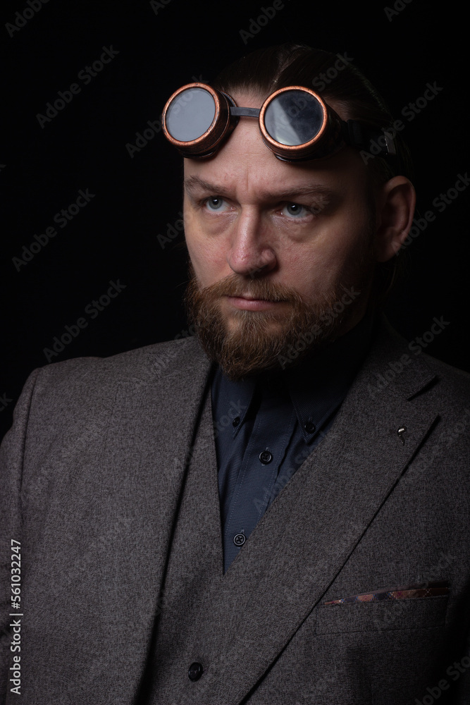 charismatic man in a classic suit and steampunk goggles on a black background stylish Portrait charismatic man in a classic suit and steampunk goggles on a black background stylish Portrait