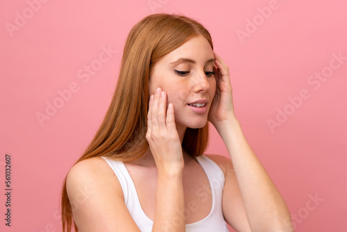 Young redhead woman isolated on pink background