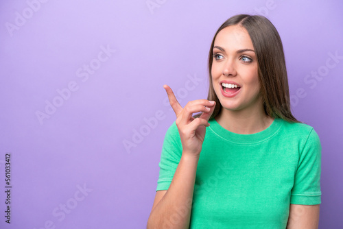 Young caucasian woman isolated on purple background intending to realizes the solution while lifting a finger up