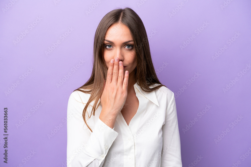 Young caucasian woman isolated on purple background covering mouth with hand Young caucasian woman isolated on purple background covering mouth with hand