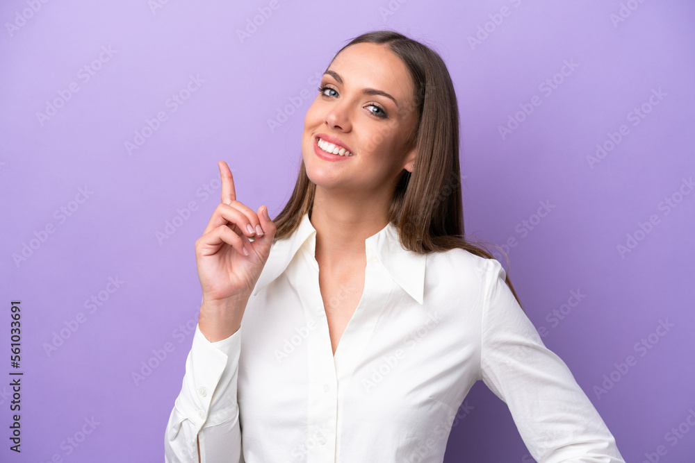 Young caucasian woman isolated on purple background showing and lifting a finger in sign of the best Young caucasian woman isolated on purple background showing and lifting a finger in sign of the best