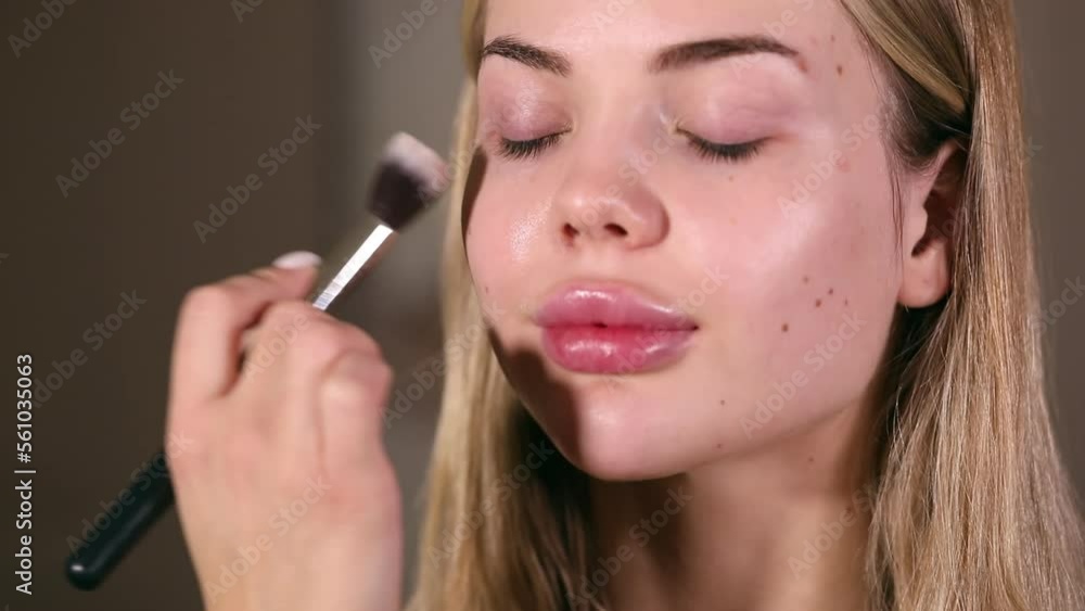The stylist applying make-up to a young model The stylist applying make-up to a young model