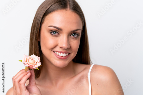 Young caucasian woman isolated on white background holding flowers with happy expression. Close up portrait