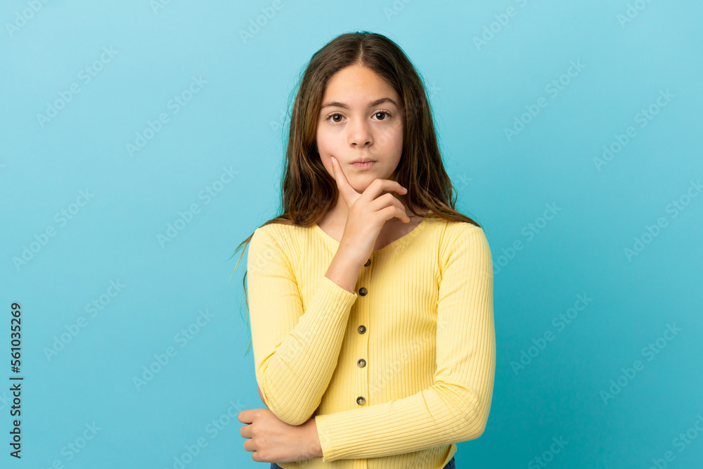 Little caucasian girl isolated on blue background and thinking Little caucasian girl isolated on blue background and thinking